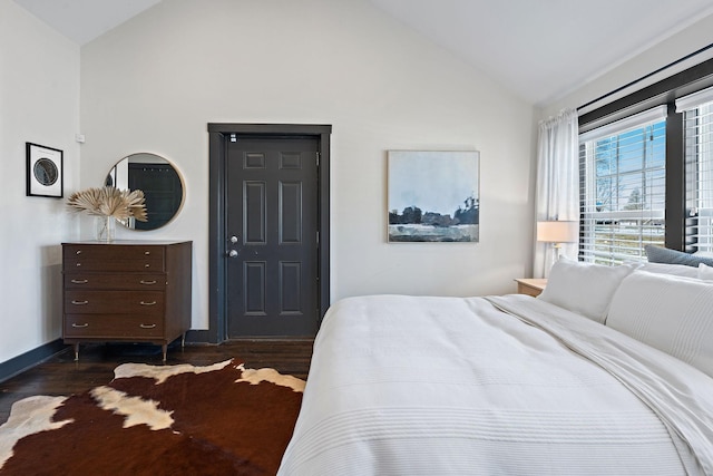 bedroom with baseboards, dark wood-style floors, and lofted ceiling