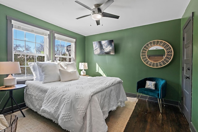 bedroom with ceiling fan, baseboards, and wood finished floors