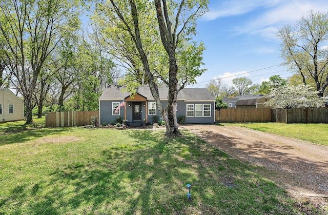 ranch-style house with a front yard, fence, and dirt driveway