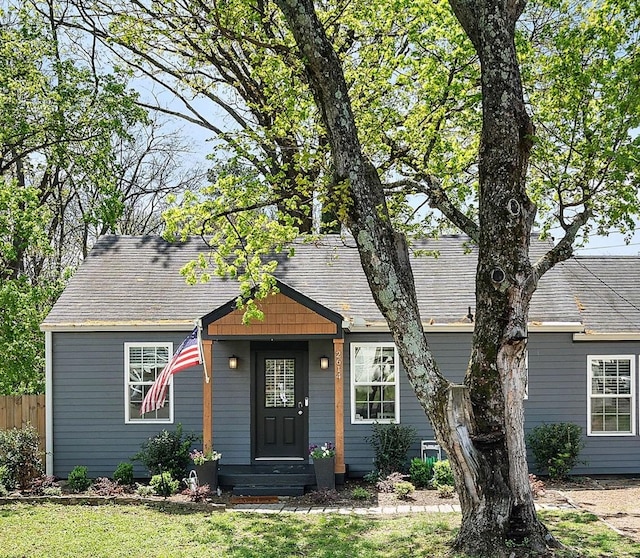view of front of home featuring fence and roof with shingles