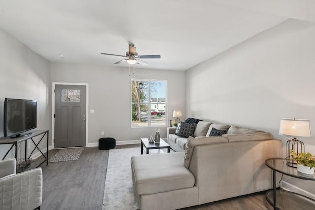 living room featuring baseboards, a ceiling fan, and wood finished floors