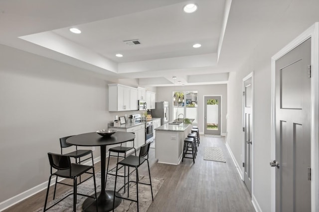 dining area with a tray ceiling, baseboards, recessed lighting, and visible vents