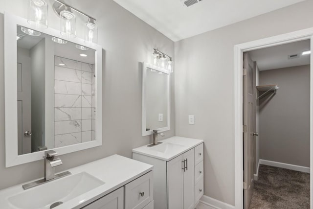 bathroom featuring a sink, baseboards, and two vanities