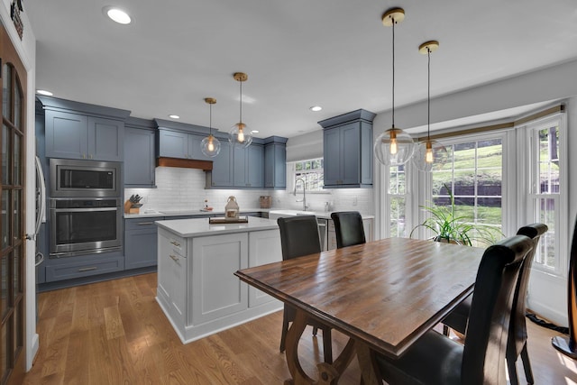 6112 Frontier Ct, Nashville, TN 37211 - kitchen featuring stainless steel appliances, a sink, decorative backsplash, wood finished floors, and light countertops