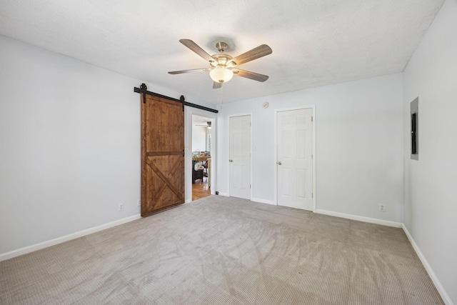 130 Gail St, Oak Grove, KY 42262 - unfurnished bedroom with a barn door, ceiling fan, baseboards, and carpet floors