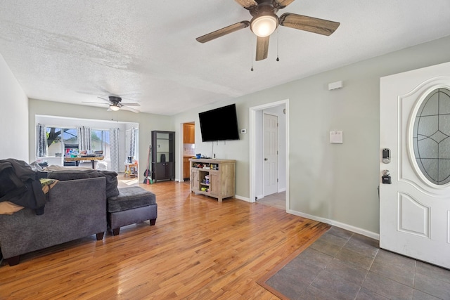 130 Gail St, Oak Grove, KY 42262 - living room featuring baseboards, light wood-type flooring, a textured ceiling, and ceiling fan