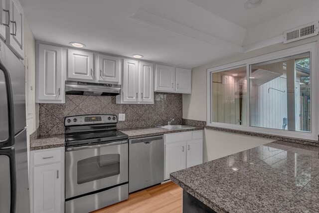 5025 Hillsboro Pike Unit 22D, Nashville, TN 37215 - kitchen with white cabinets, under cabinet range hood, visible vents, and appliances with stainless steel finishes