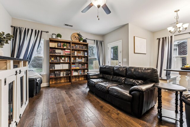 living room featuring dark wood-type flooring, visible vents, and a wealth of natural light