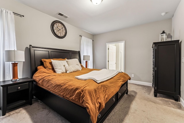 bedroom featuring visible vents, light colored carpet, and baseboards