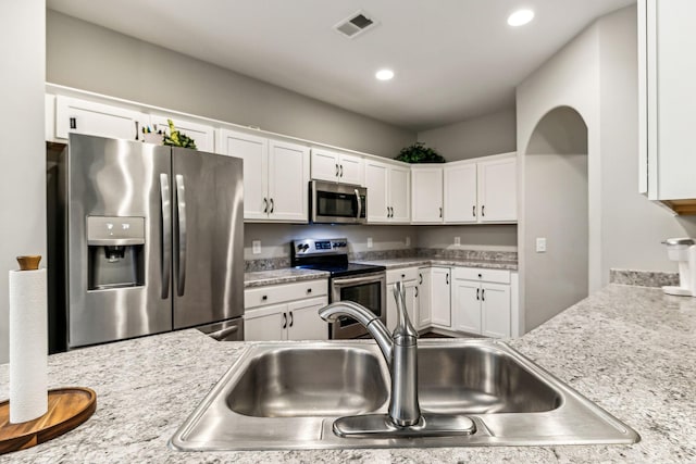 kitchen with white cabinetry, visible vents, light countertops, a sink, and stainless steel appliances