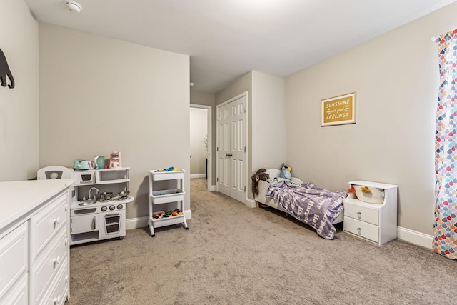 bedroom with baseboards and light colored carpet