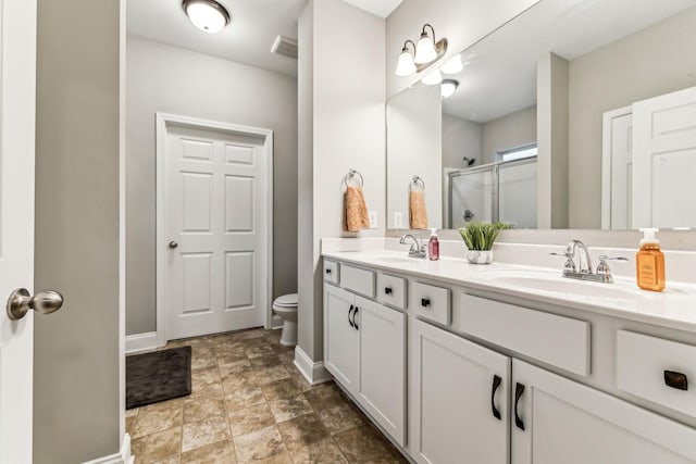 full bath with a shower stall, baseboards, a sink, and toilet