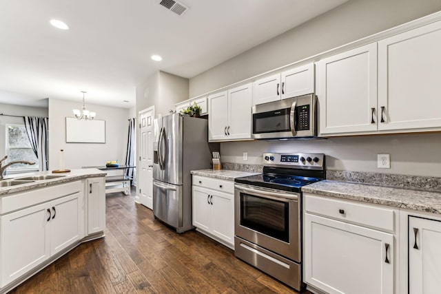 kitchen with white cabinetry, visible vents, a chandelier, a sink, and stainless steel appliances