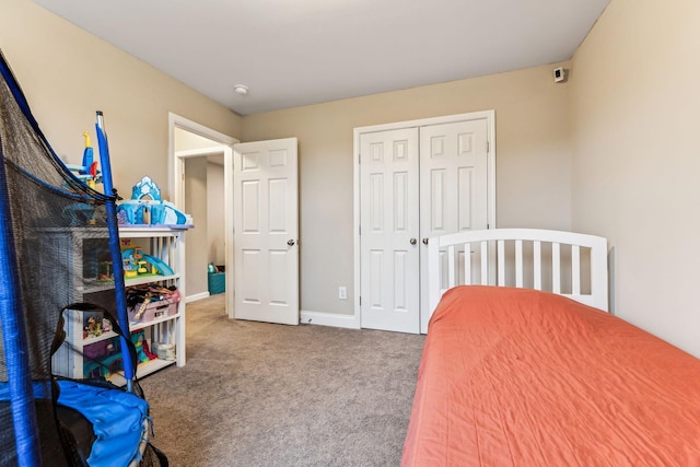bedroom featuring a closet, baseboards, and carpet