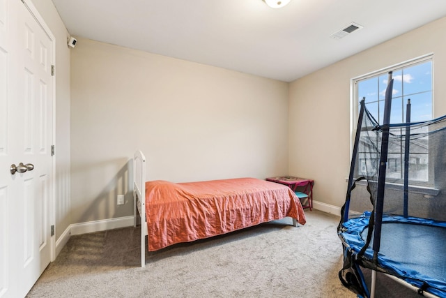 bedroom with visible vents, baseboards, and carpet