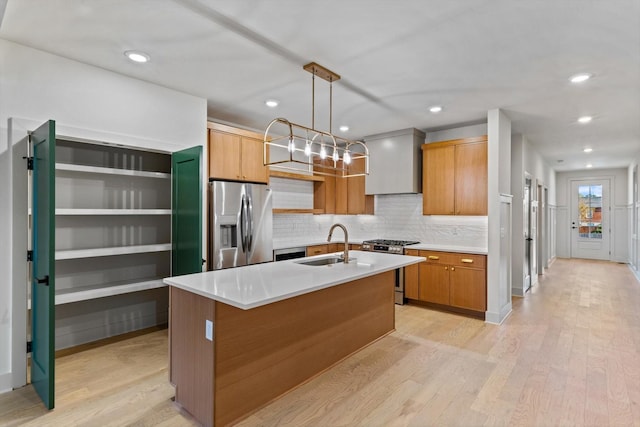 kitchen featuring a sink, stainless steel appliances, light wood-style flooring, premium range hood, and backsplash