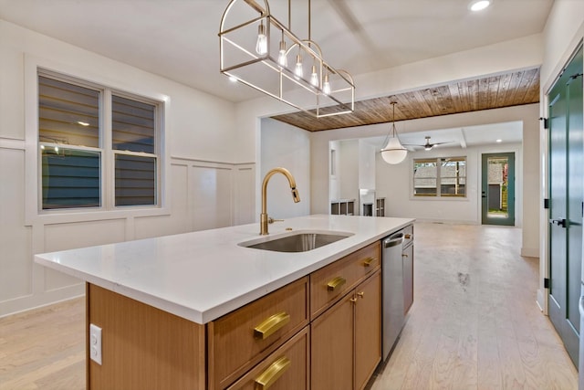 kitchen with dishwasher, light wood finished floors, open floor plan, and a sink
