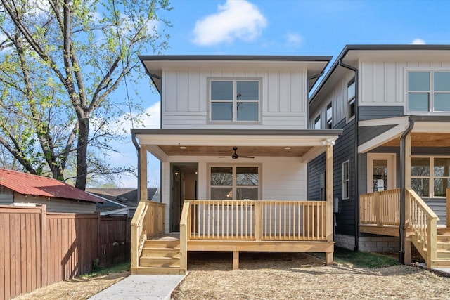view of front of house with board and batten siding, covered porch, a ceiling fan, and fence