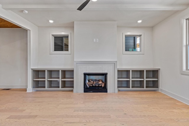 unfurnished living room with wood finished floors, baseboards, a fireplace, and a ceiling fan