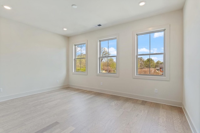 spare room with recessed lighting, light wood-style flooring, visible vents, and baseboards