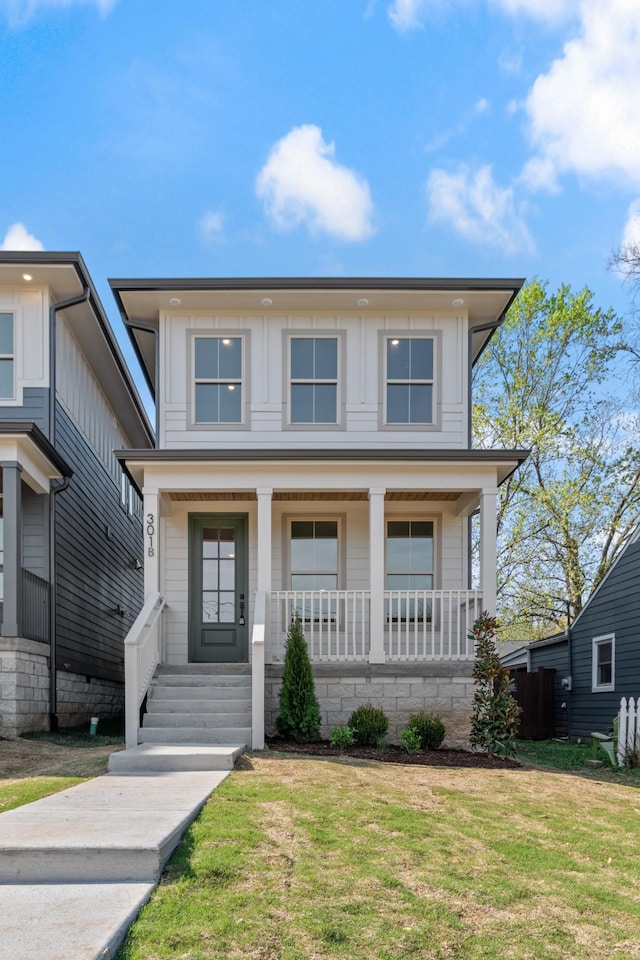 view of front facade with a front yard and covered porch