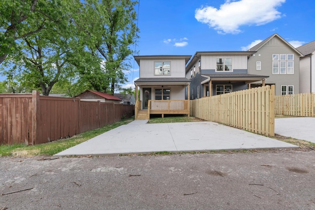 rear view of house featuring ceiling fan, fence private yard, and covered porch