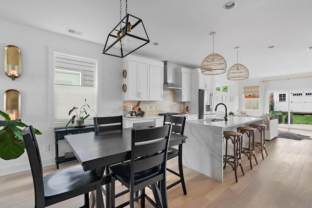 dining room featuring recessed lighting, plenty of natural light, light wood-style flooring, and visible vents