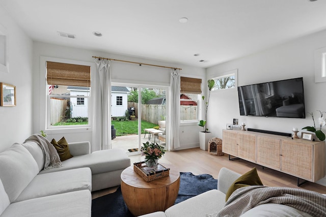 living area featuring light wood finished floors and visible vents