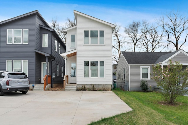 contemporary home with concrete driveway and a front lawn