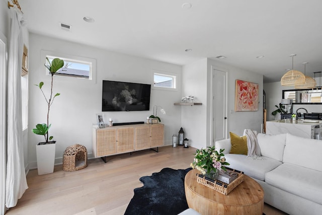 living area featuring light wood-style flooring, baseboards, visible vents, and recessed lighting