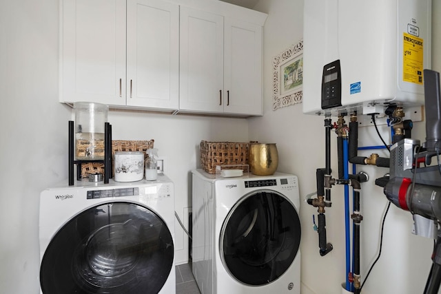 laundry room featuring water heater, independent washer and dryer, and cabinet space