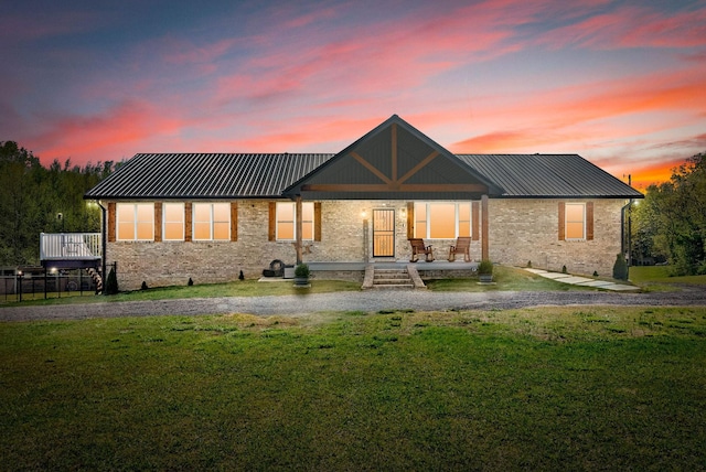 779 Iron Workers Rd W, Clarksville, TN 37043 - back of property at dusk with brick siding, a yard, and metal roof
