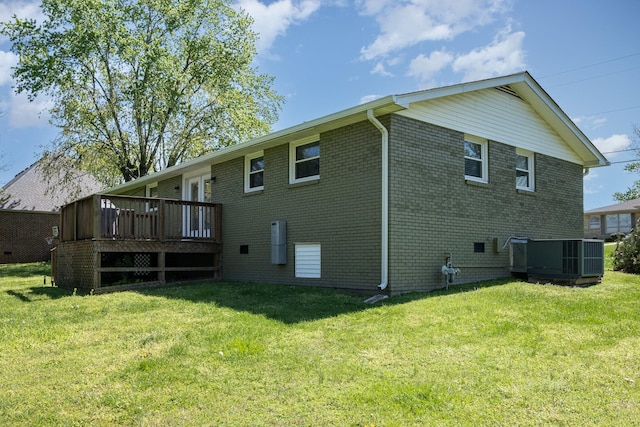 rear view of house featuring a deck, a yard, central AC unit, and brick siding