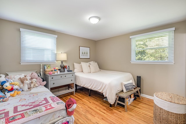 bedroom with light wood-type flooring and baseboards
