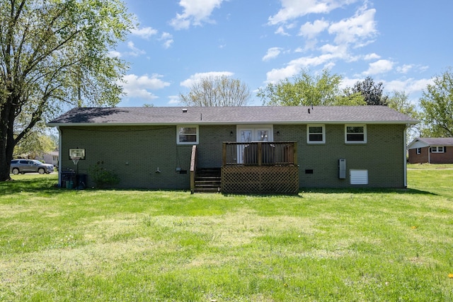 rear view of house featuring brick siding, a wooden deck, and a lawn