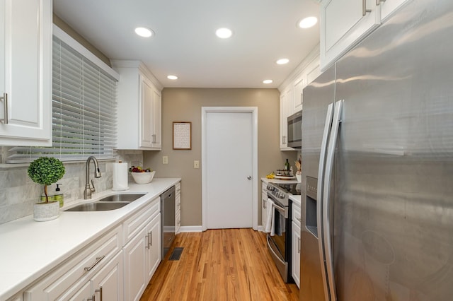 kitchen with a sink, recessed lighting, appliances with stainless steel finishes, and white cabinetry
