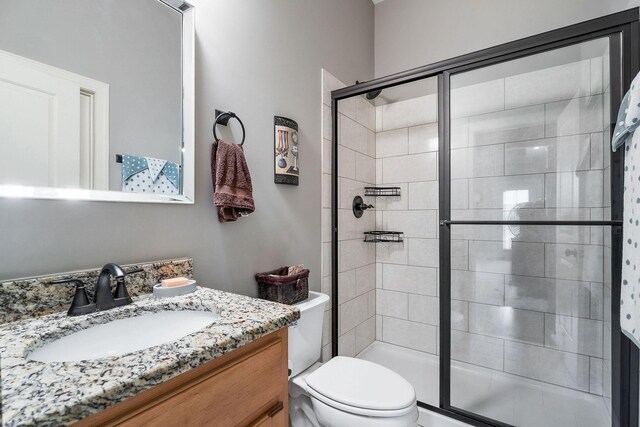 full bath with toilet, a shower stall, and vanity