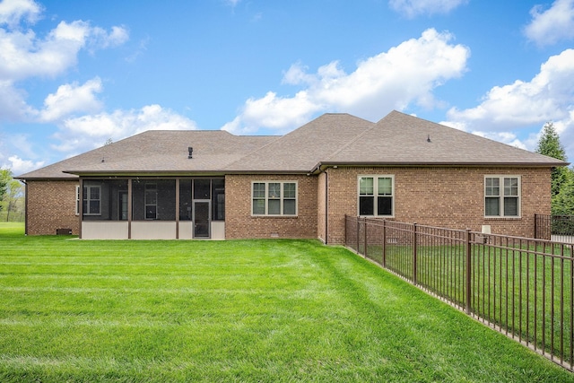 rear view of house with a sunroom, a fenced backyard, a lawn, roof with shingles, and brick siding