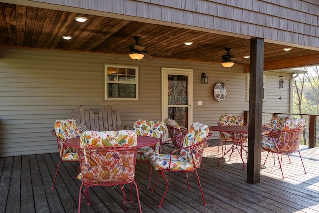 wooden terrace featuring outdoor dining space and ceiling fan