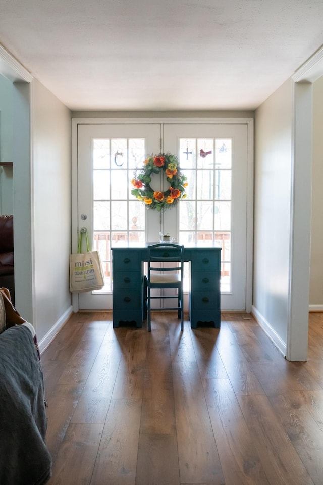 living area with wood finished floors, baseboards, and a wealth of natural light