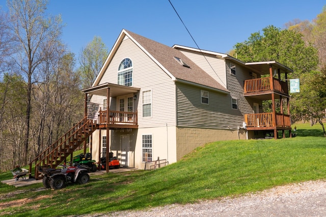 rear view of property with stairs, roof with shingles, and a lawn
