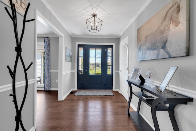 entryway with a notable chandelier, hardwood / wood-style flooring, crown molding, and a healthy amount of sunlight