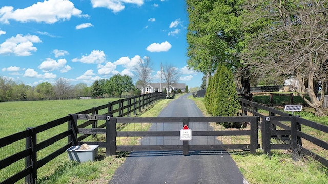 view of road with a rural view and a gate