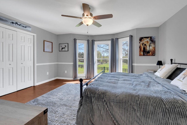 bedroom featuring wood finished floors, a closet, baseboards, and a ceiling fan