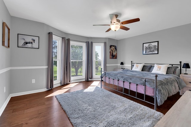 bedroom with ceiling fan, baseboards, and wood finished floors