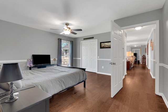 bedroom with dark wood-type flooring, a closet, baseboards, and a ceiling fan
