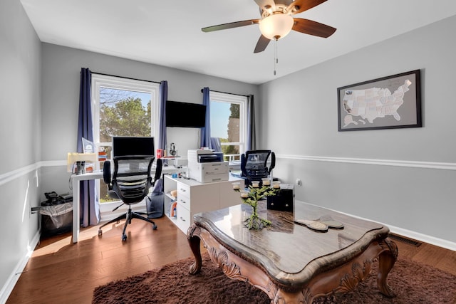 office featuring wood finished floors, ceiling fan, baseboards, and visible vents