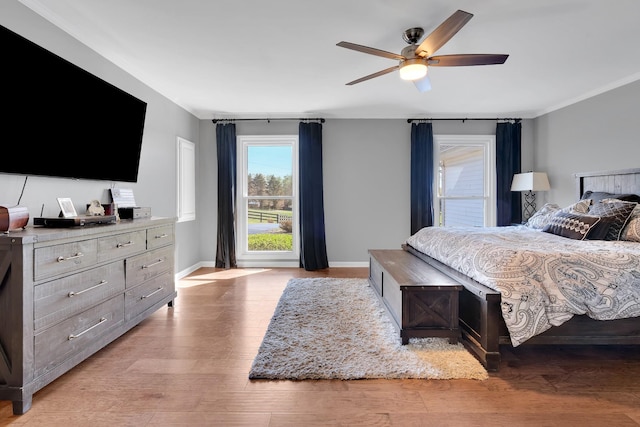 bedroom with light wood-type flooring, baseboards, and ornamental molding