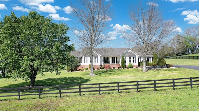 ranch-style house with brick siding, a front yard, and a fenced front yard
