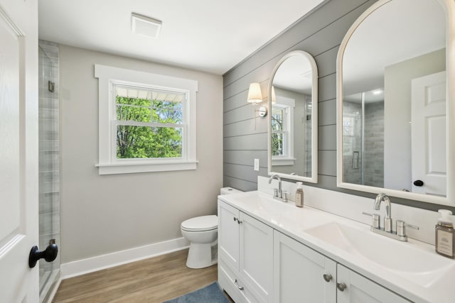 bathroom with toilet, wood finished floors, a sink, and baseboards